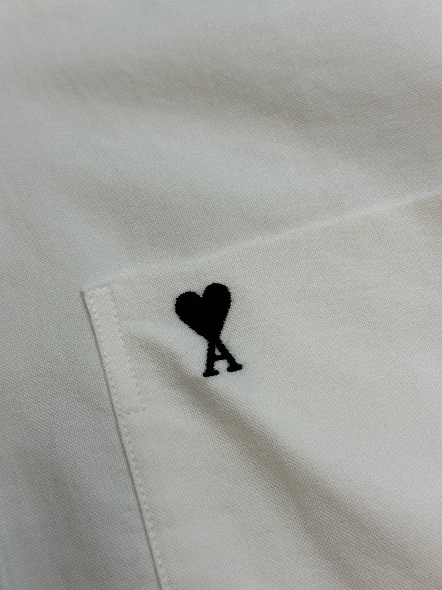 Ami love heart embroidered short-sleeved shirt is made of custom-made high-density double-ply oxford fabric. The black silk thread is embroidered with love hearts on the chest. It is low-key and powerful. It is bounded by pockets and hides French romance. Using imported machine embroidery technology, advanced computer control systems and precision mechanical components, Ami love embroidery operations are realized. size:37.38.39.40